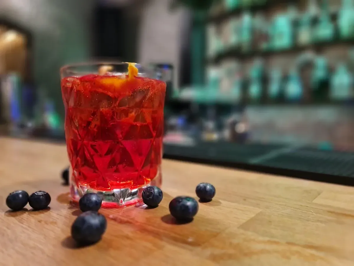 Negroni with blueberries, on the bar