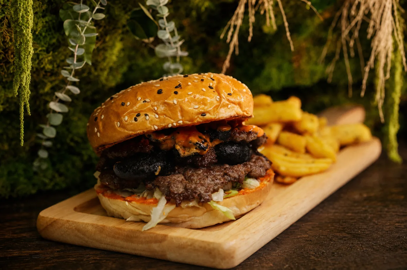 The Old Town Burger on a wooden board, with fries