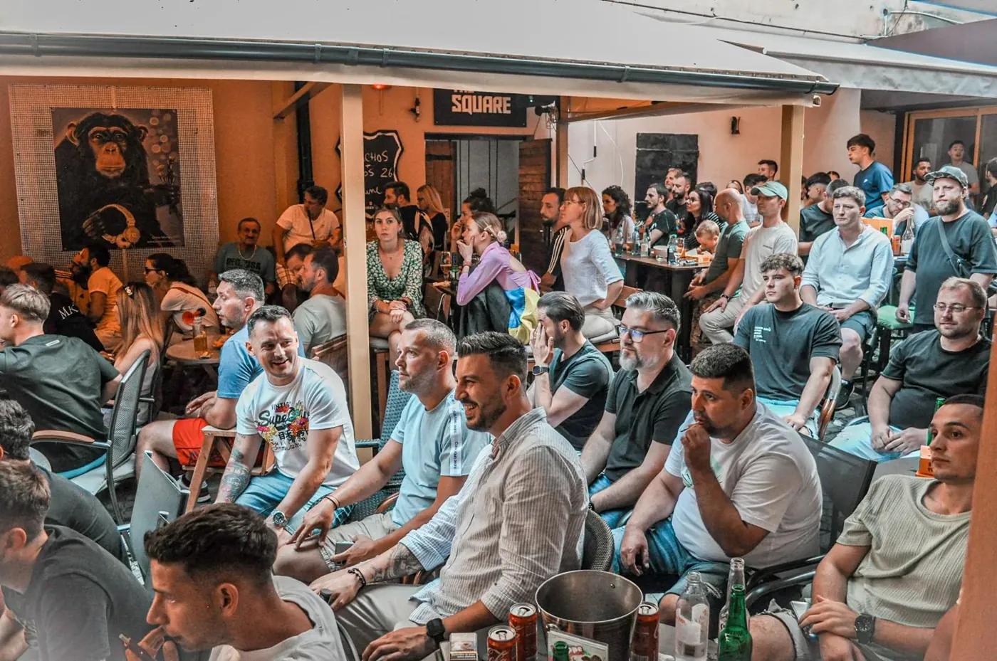 The match on screen, a full terrace